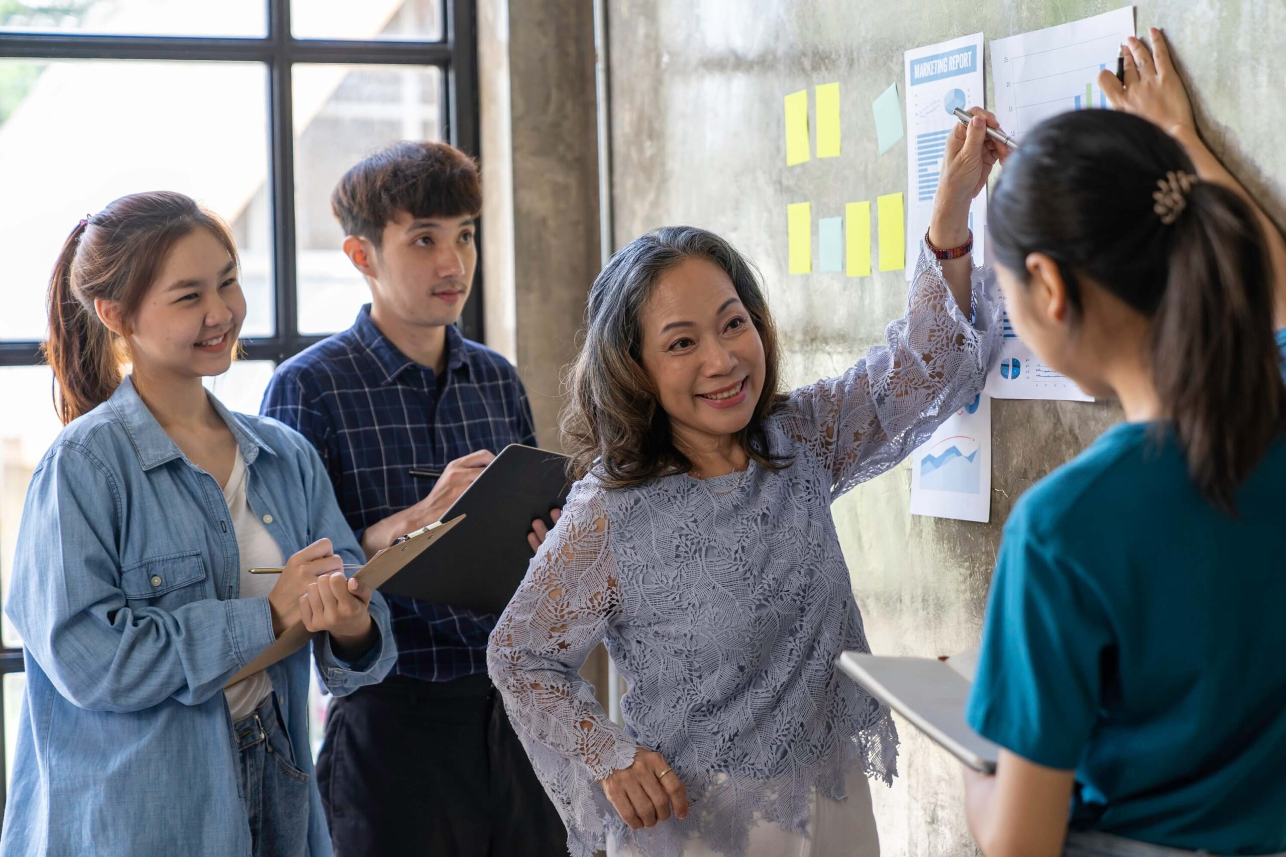 Asian businesswomen collaborating on a business strategy for Innovation Behavior Services in a modern office setting.