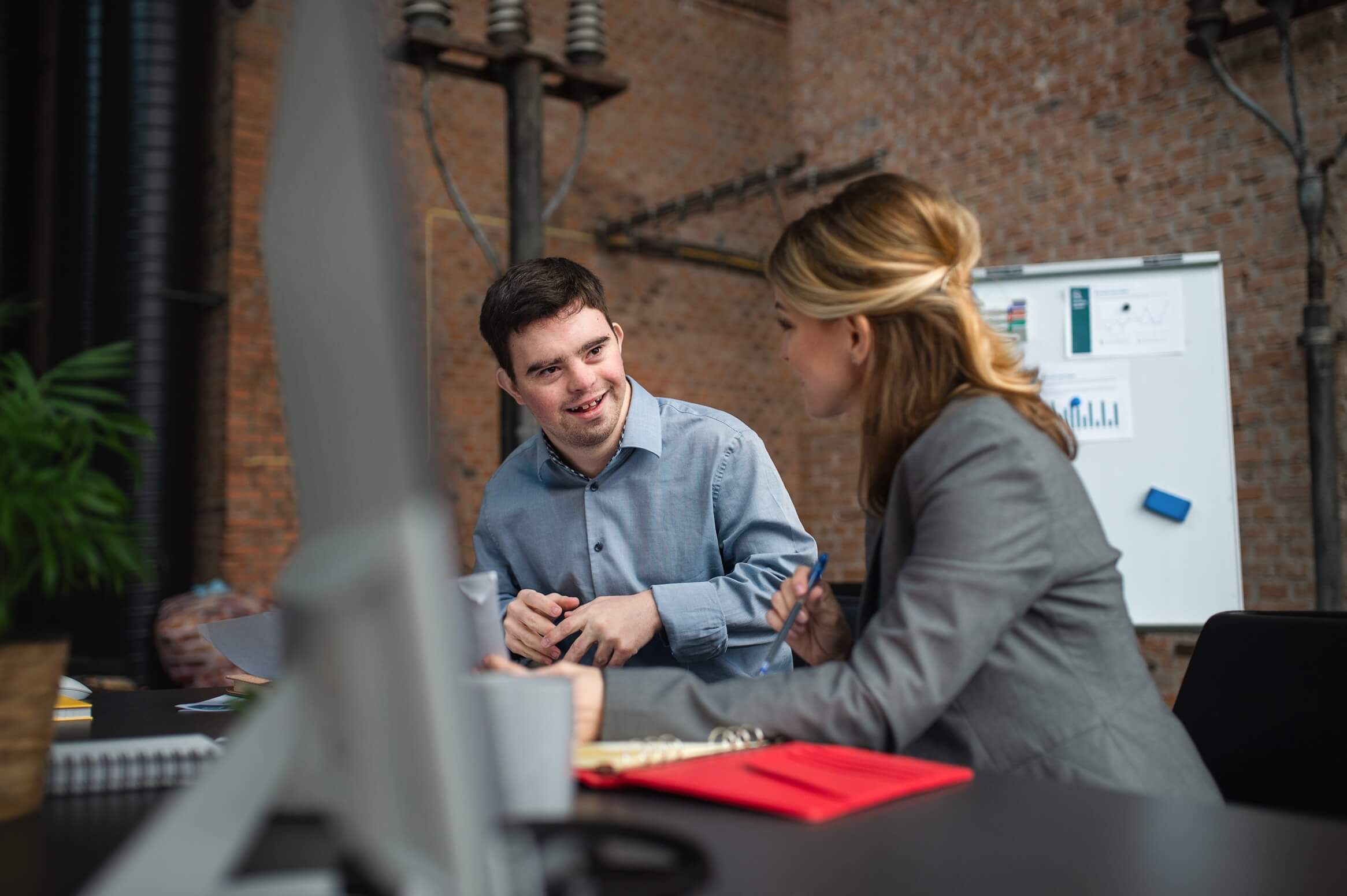 Two colleagues discussing ideas in an office setting at Innovation Behavior Services.
