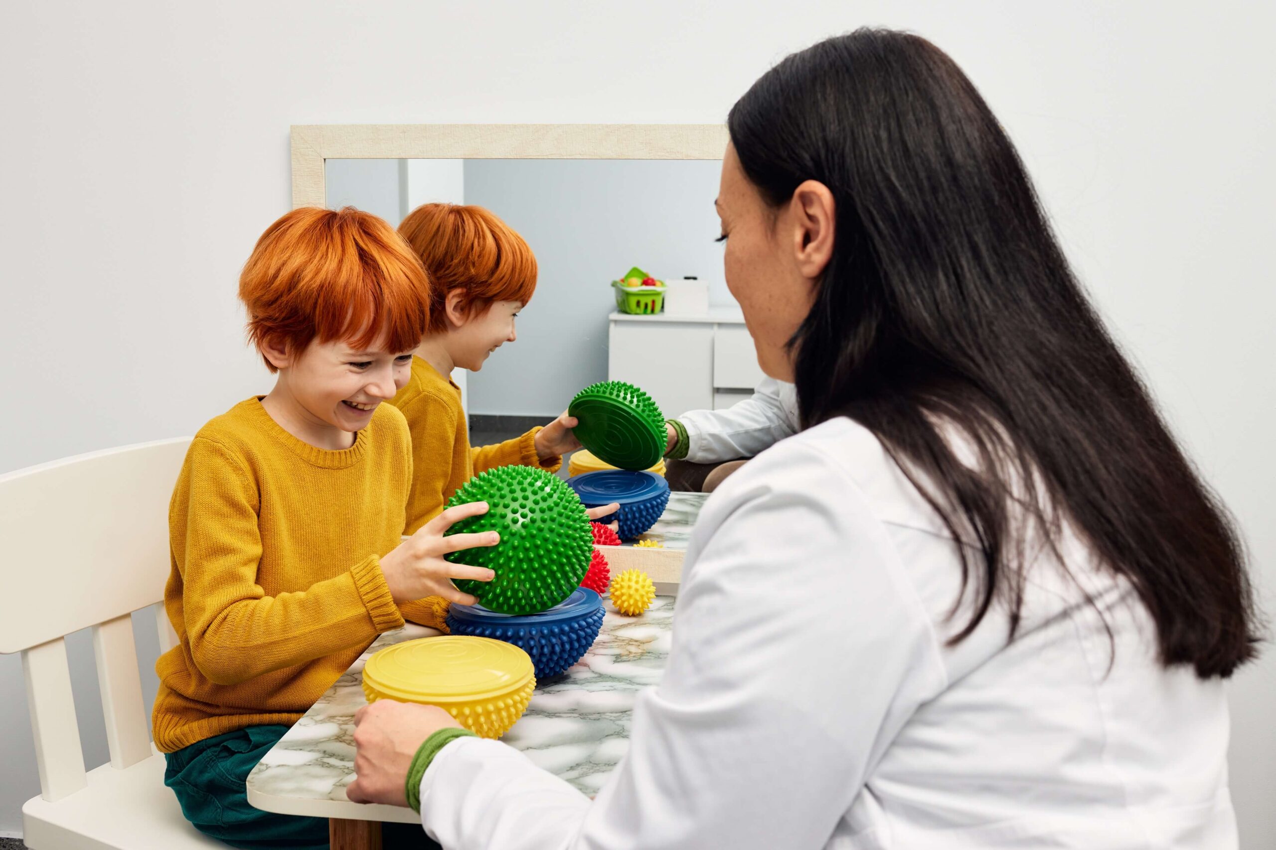 Child participating in autism therapy session with a therapist.
